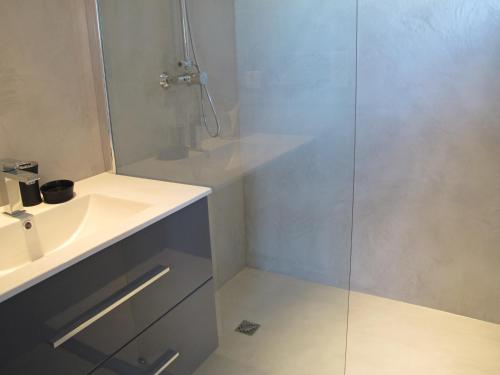 uma casa de banho com um lavatório branco e um chuveiro em L'Esperluette em Suze-la-Rousse