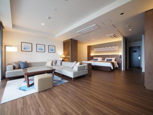 恩納村にあるHIYORIオーシャンリゾート沖縄のベッドとリビングルームが備わるホテルルームです。