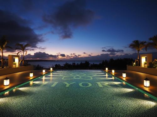 a swimming pool with lights on top of a building at Hiyori Ocean Resort Okinawa in Onna