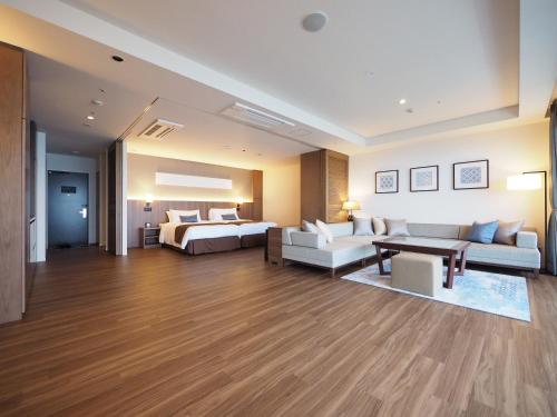 a hotel room with a couch and a bed at Hiyori Ocean Resort Okinawa in Onna