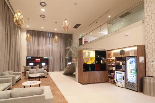 a living room with couches and a tv at Holiday Inn & Suites Monterrey Apodaca Zona Airport, an IHG hotel in Monterrey