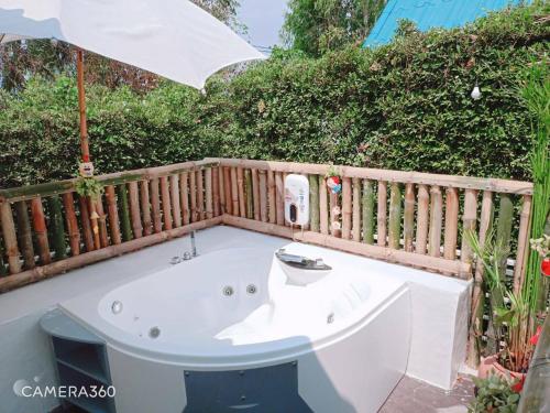a white bath tub sitting under an umbrella at Terrua Main Ten Villa Garden in Suan Phung