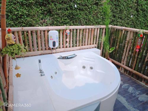a white bath tub sitting next to a wooden fence at Terrua Main Ten Villa Garden in Suan Phung
