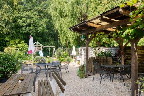 a patio with tables and chairs in a garden at Kirchenwirt Durlacher in Kaibing