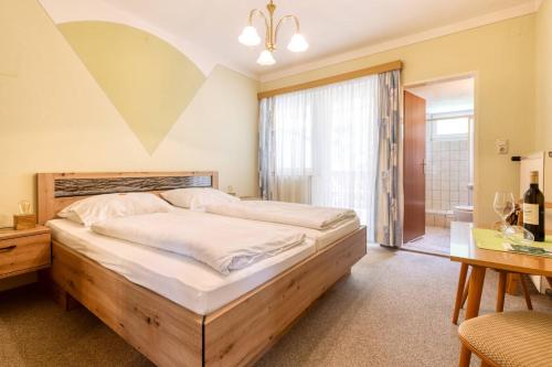 1 dormitorio con 1 cama grande y 1 mesa en Kirchenwirt Durlacher en Kaibing