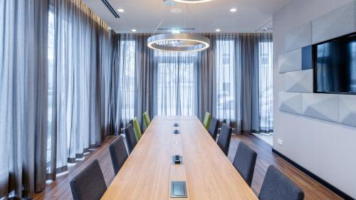 a conference room with a long wooden table and chairs at Holiday Inn Express Munich - City East by IHG in Munich