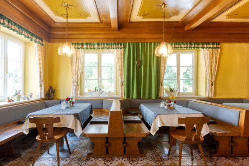 Kaibing的住宿－Kirchenwirt Durlacher，一间设有两张桌子和绿帘的用餐室