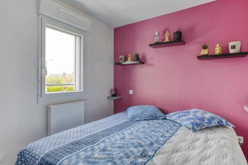 1 dormitorio con cama y pared de color rosa en Rose des Vents, en Damgan