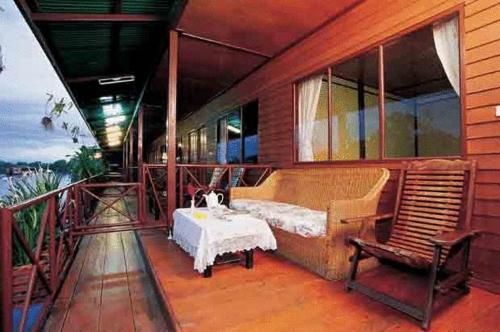 a room with a bed and a table on a balcony at Duenshine Resort in Kanchanaburi