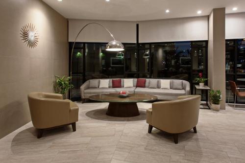 a living room with a couch and a table and chairs at Holiday Inn Long Beach - Airport by IHG in Long Beach
