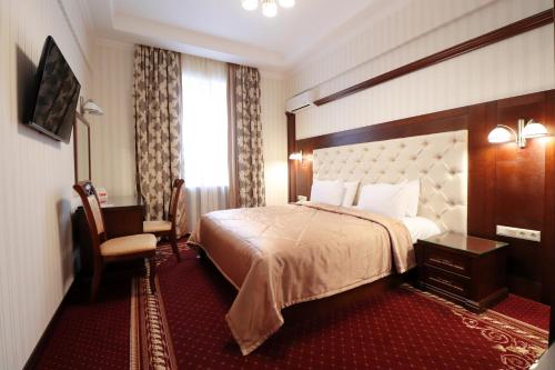 Habitación de hotel con cama y silla en Ukraine Hotel en Kiev