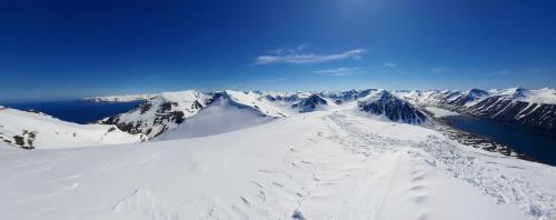 a view of a snow covered mountain with a lake at Hlíðarvegur 20 - Gagginn in Siglufjörður