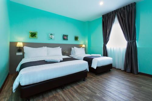 a blue room with two beds and a window at DK Hotel in Johor Bahru