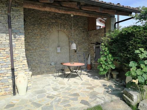 a patio with a table and chairs in a brick building at Agriturismo Sondrea in Sinio
