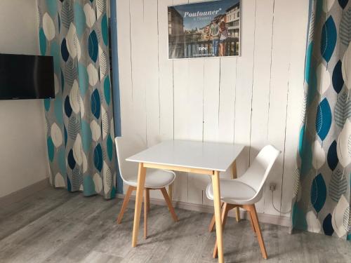 un tavolo bianco e due sedie in una stanza di Les Balcons du Pastel a Puylaurens