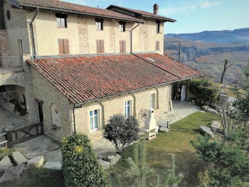 a large stone house with a red roof at Agriturismo Sondrea in Sinio