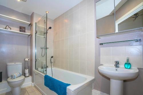 y baño con lavabo, aseo y ducha. en The Augustine - Modern two Bed Ground floor apartment with parking en Canterbury