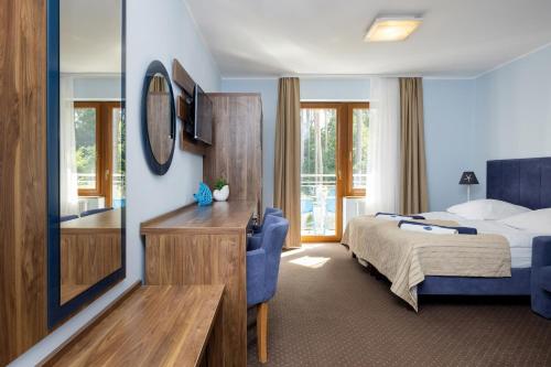 a hotel room with a bed and a mirror at VivaLaMer in Pobierowo