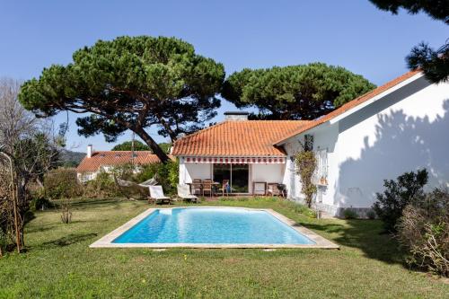 シントラにあるALTIDO Idyllic House With Pool and Garden in Colaresのヴィラ(家の前にスイミングプール付)