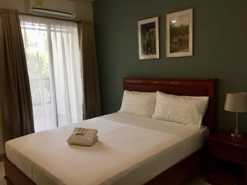 a bedroom with a white bed with a window at Bohol Ecotel in Tagbilaran City