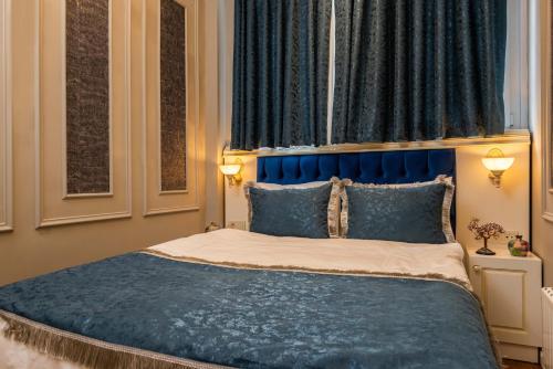 a bed with a blue headboard in a bedroom at Begonville Mansion Oldcity in Istanbul