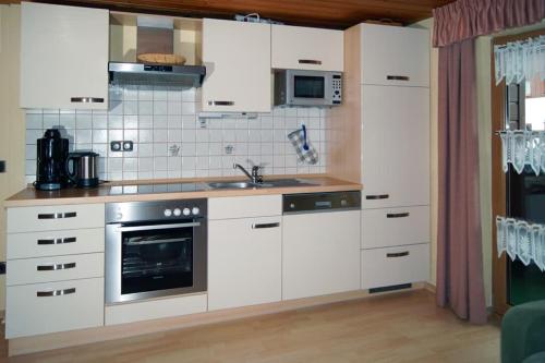a kitchen with white cabinets and a sink at Ferienwohnungen Meindl in Lam