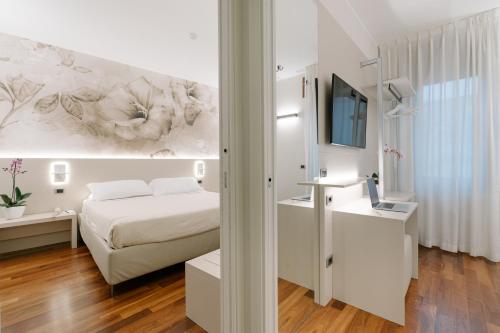a white bedroom with a bed and a tv at Hotel Giulietta e Romeo ***S in Verona