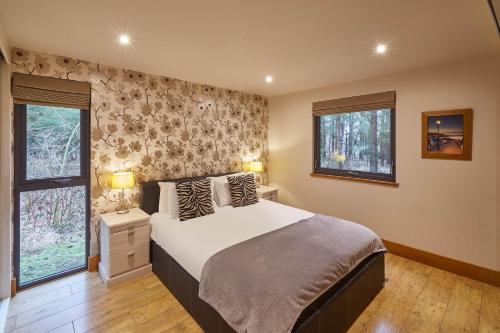 a bedroom with a large bed and two windows at Host & Stay - Simon Howe Lodge in Whitby