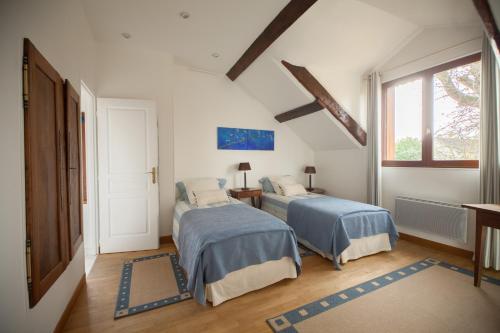 a bedroom with two beds and a window at Ferme des Vallees in Soindres