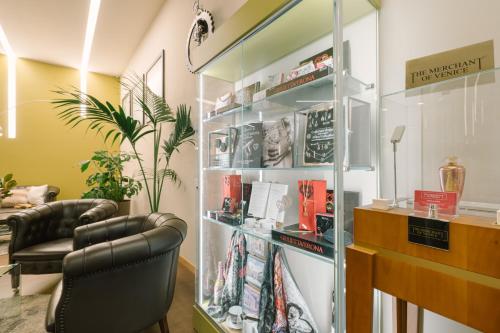 a room with two chairs and a book shelf with books at Hotel Giulietta e Romeo ***S in Verona