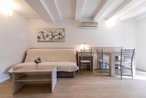 a room with a bed and a table and a dining room at Apartments Crneković III in Baška