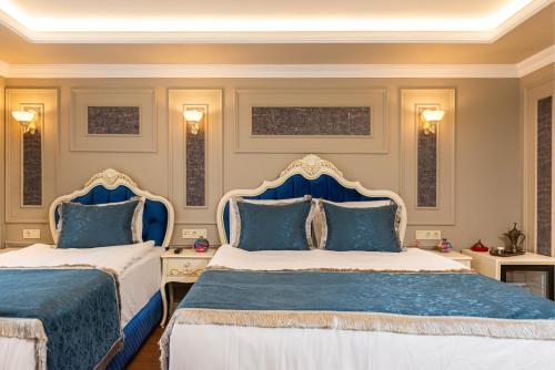 two beds in a bedroom with blue and white at Begonville Mansion Oldcity in Istanbul