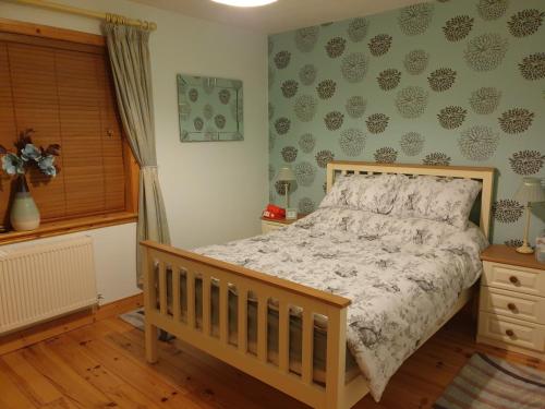 a bedroom with a bed and a window at Drumcoura Dreamescape in Ballinamore