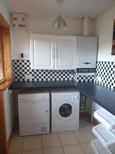a kitchen with a washer and dryer under a counter at Drumcoura Dreamescape in Ballinamore