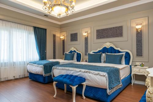 a bedroom with two beds and a chandelier at Begonville Mansion Oldcity in Istanbul