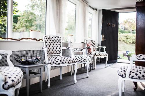 Habitación con sillas blancas, mesa y ventana en Norsminde Kro Anneks, en Odder