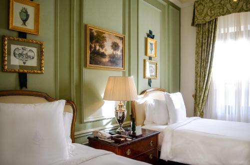 a bedroom with two beds and a lamp and a window at Four Seasons Hotel Firenze in Florence
