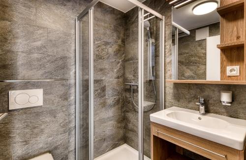 y baño con ducha y lavamanos. en Alpenblick Apartments Montafon by A-Appartments en Schruns-Tschagguns