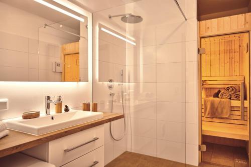 a white bathroom with a sink and a shower at Adler Lodge D3 by AA Holiday Homes in Tauplitz