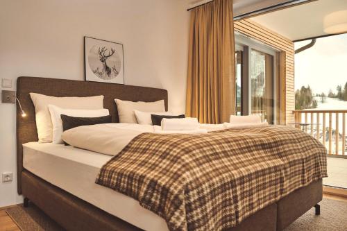 a bedroom with a large bed and a balcony at Adler Lodge D3 by AA Holiday Homes in Tauplitz