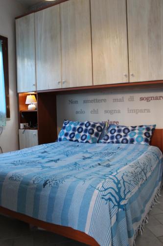 une chambre avec un lit avec une couette bleue et blanche dans l'établissement BEACH HOUSE STEFI, à Golfo Aranci