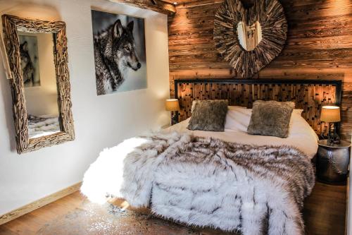 a bedroom with a bed and a mirror at La Ferme du Lac Vert in Montriond