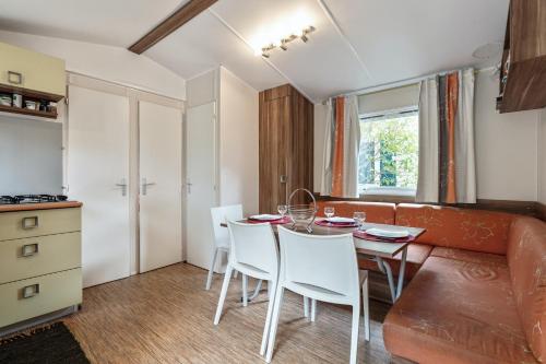 une cuisine et une salle à manger avec une table et des chaises dans l'établissement Bungalow convivial près de Sète avec piscine partagée, à Mèze