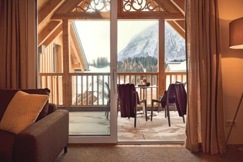 a living room with a view of a mountain through a glass door at die Tauplitz Lodges - Alm Lodge A13 by AA Holiday Homes in Tauplitz