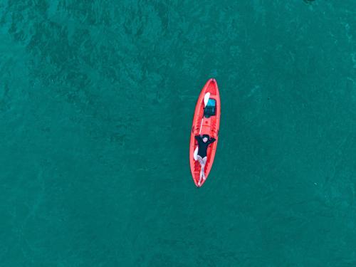 a red boat in the middle of the water at Mai Chau Hideaway Lake Resort in Mai Chau