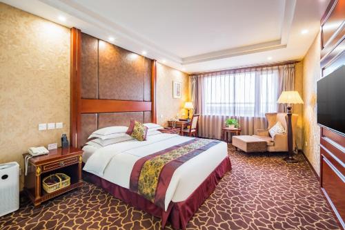 um quarto de hotel com uma cama grande e uma sala de estar em Beijing Commercial Business Hotel em Pequim