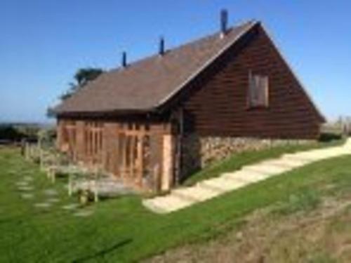 a building in a field next to a green field at Surf Shack 1-Bed Cottage Sleeps 2 Pet Friendly in Shorwell