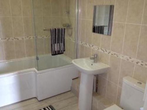 y baño con lavabo, bañera y aseo. en Surf Shack - Impeccable 1-Bed Cottage in Shorwell, en Shorwell