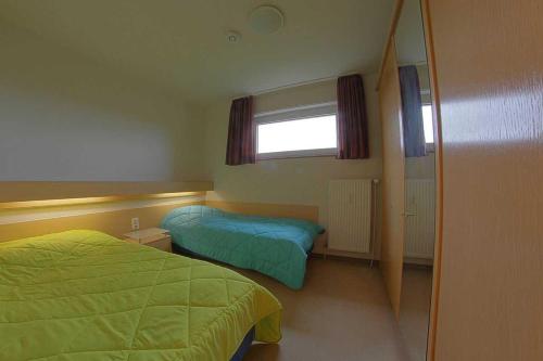 a bedroom with two beds and a window and a mirror at Apartment 480 in Hohegeiß