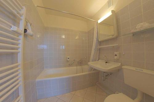 a bathroom with a sink and a tub and a toilet at Apartment 480 in Hohegeiß
